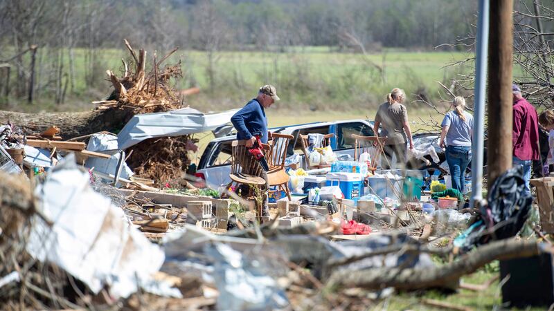 A family moves furniture out of their destroyed home in Adamsville, Tenn. on Saturday, April...