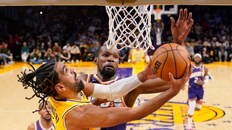 Los Angeles Lakers guard Gabe Vincent, left, shoots as Phoenix Suns forward Kevin Durant...