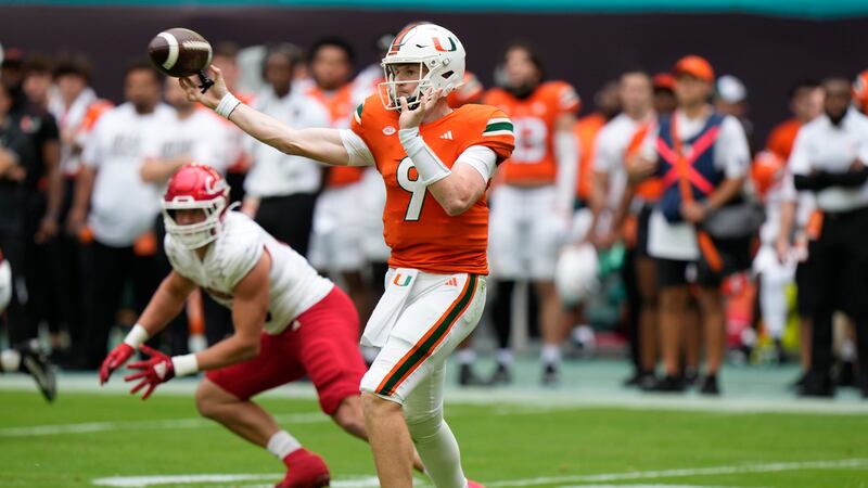 Miami quarterback Tyler Van Dyke (9) passes against Louisville defensive lineman Mason Reiger...